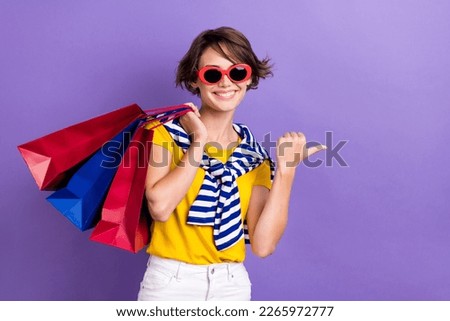 Photo of cheerful lady wear stylish striped summer outfit arm demonstrate empty space seasonal offer isolated on purple color background
