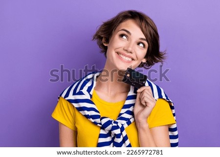 Photo of dreamy sweet lady dressed tied jumper holding bank card looking empty space isolated violet color background