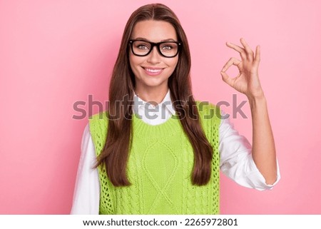 Portrait of positive optimistic woman with long hairdo wear green waistcoat showing okey approve isolated on pink color background