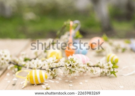 Happy Easter. Easter eggs on rustic table with cherry blossoms. Natural dyed colorful eggs and spring flowers. Countryside still life