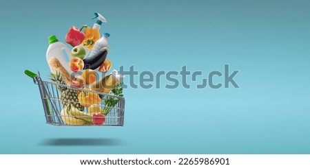 Fresh groceries and goods falling in a supermarket trolley, grocery shopping concept Royalty-Free Stock Photo #2265986901