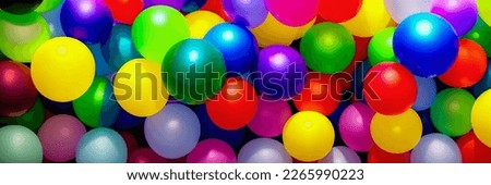 Colorful, vibrant, and fun-filled image featuring an assortment of inflatable balloons. photo would be great for use in greeting cards, invitations, posters, or any project requires festive vibe.