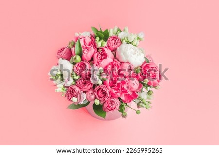 big bouquet of peonies in a box on a pink background top view copy space. Greeting card with March 8 or mother's day