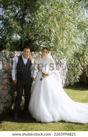 young couple the groom in a plaid suit and the bride in a chic white dress in nature