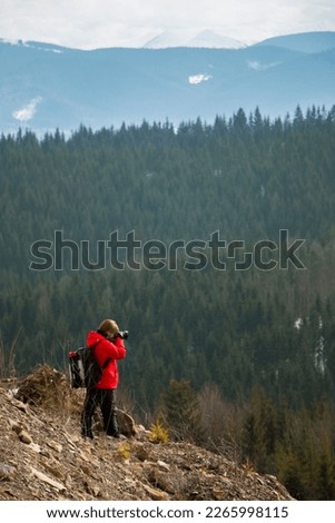 Photographer with mountains and forest background