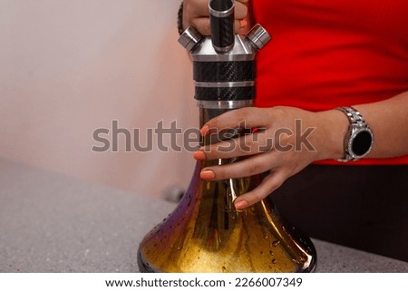 a girl in a cap prepares hookah