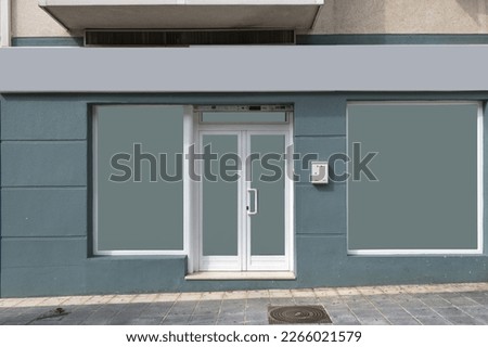 Front facades of premises at street level with opaque windows and greyish-blue walls