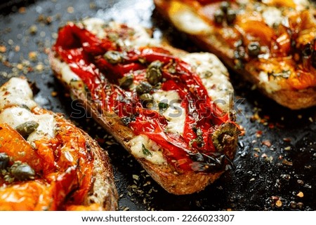 Close up view of grilled sandwich, bruschetta with mozzarella cheese, grilled peppers, capers and herbs Royalty-Free Stock Photo #2266023307