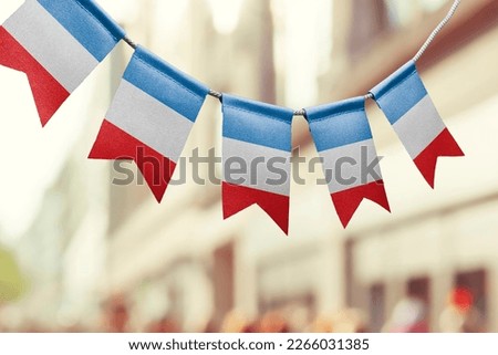 A garland of France national flags on an abstract blurred background.