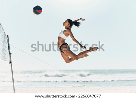 Sports woman jump at volleyball beach summer outdoor competition game on ocean or sea sand playing to win. Healthy, fitness and training agile girl or young athlete ready hit ball over net in match Royalty-Free Stock Photo #2266047077