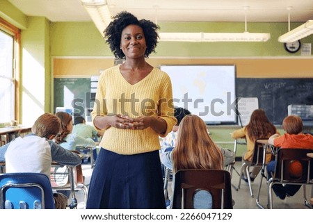 Portrait, teacher and black woman with students learning in classroom. Education, scholarship and happy, proud and young female educator with children ready for studying or knowledge in middle school Royalty-Free Stock Photo #2266047129