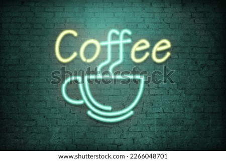 Glowing neon sign with cup and word Coffee on brick wall