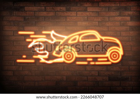 Glowing neon sign with driving car and flames on brick wall