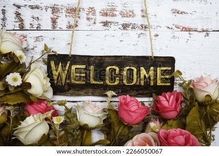 Welcome Sign with flowers frame decorate on wooden background