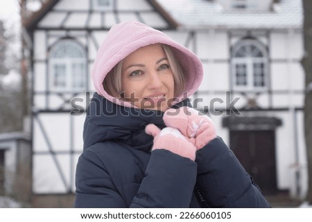 The girl enjoys the snow and drinks hot coffee. Winter fashion.
