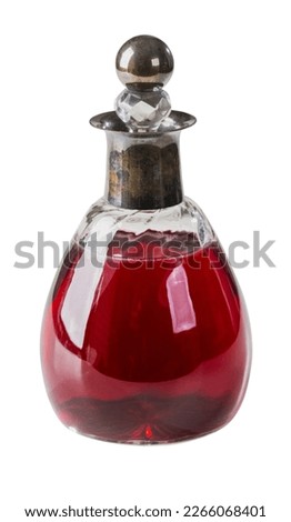 Old bottle with red beverage isolated on white background
