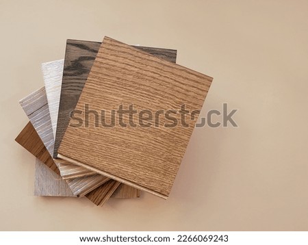 Engineered hardwood or laminate flooring swatch samples in various type of wood texture, isolated on beige background. A variety of shades of wood floor material.  Royalty-Free Stock Photo #2266069243
