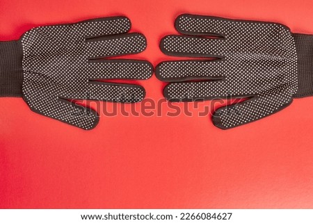 Garden gloves on a red background. Graphic background for gardening concept.