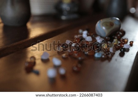 Semi-precious multi-colored stones on a dark wooden table, amber, opal, quartz on a blurred background