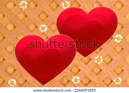 Red hearts made of shiny colored paper on a decorative lattice with white daisies.