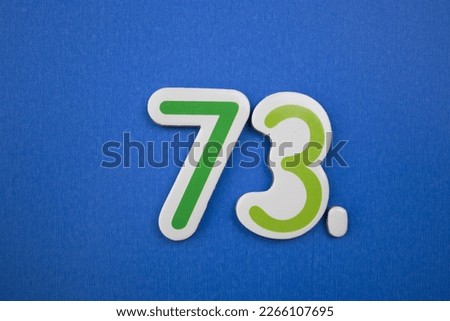 The inscription 73, colorfully written, placed over a blue background.