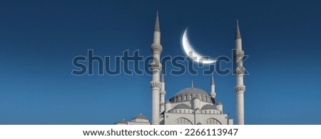 Ramadan concept - Ramadan kareem. Tall white minarets, mosque dome and crescent in the sky. Religious background image. Royalty-Free Stock Photo #2266113947