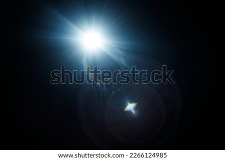 Easy to add lens flare effects for overlay designs or screen blending mode to make high-quality images. Abstract sun burst, digital flare, iridescent glare over black background. Royalty-Free Stock Photo #2266124985