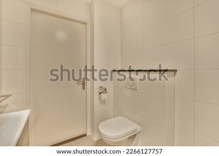 a bathroom with white tiles on the wall and door to the toilet in the background is an open shower stall Royalty-Free Stock Photo #2266127757