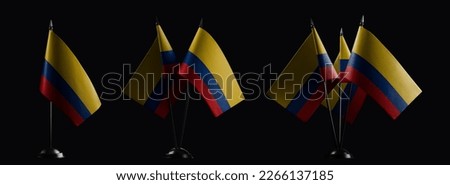 Small national flags of the Colombia on a black background.
