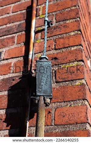 Lightning rod cable on the facade of a brick building.