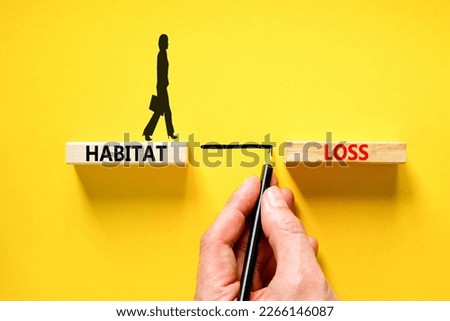 Habitat loss symbol. Concept words Habitat loss on wooden block. Beautiful yellow table yellow background. Businessman hand. Businessman icon. Business habitat loss concept. Copy space.