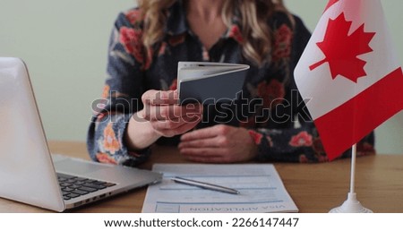 Canadian woman consular officer giving passport to male immigrant, work visa, citizenship. Visa Application online form immigration concept. Visa approval. Royalty-Free Stock Photo #2266147447