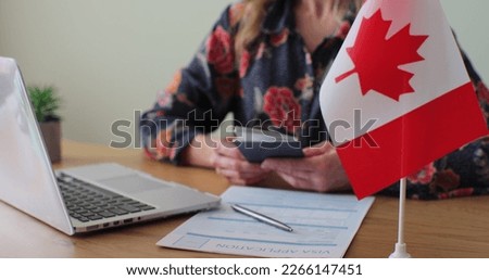 Canadian woman consular officer giving passport to male immigrant, work visa, citizenship. Visa Application online form immigration concept. Visa approval. Royalty-Free Stock Photo #2266147451