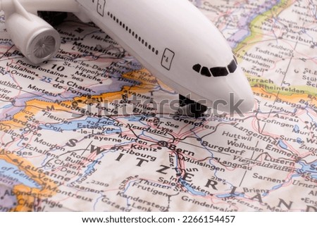 Close up of map with miniature plane highlighting Bern, Switzerland through selective focus, shallow depth of field, background blur