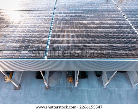 Asphalt plant garage for heavy machinery, with solar panels on rooftop, aerial view