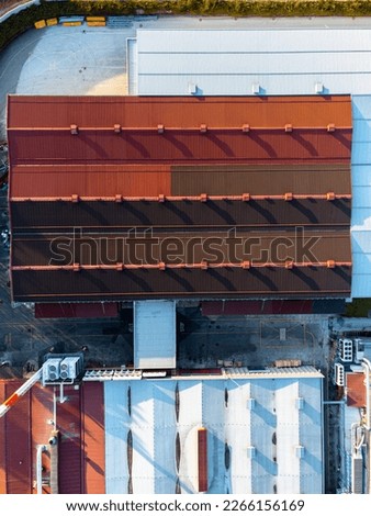 Top down view of a warehouse with a red roof, industrial site.