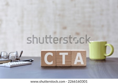 There is wood cube with the word CTA. It is an acronym for Call To Action an eye-catching image.