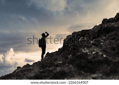 Man getting ready to climb up mountain looking up at the challenge before him planning path. Believe in yourself, overcoming challenges, pushing forward concept.	 Royalty-Free Stock Photo #2266164507