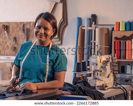 Portrait of mature Latin woman in a sewing workshop. Royalty-Free Stock Photo #2266172885