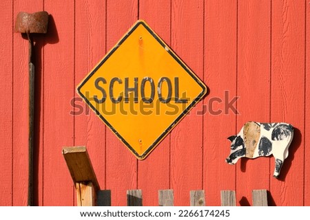 old yellow school street sign on side of a red barn - farm decorations