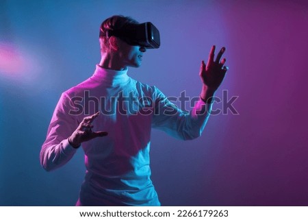 VR guy play virtual battle game at meta verse and dive as digital character in cyber and fantasy world while live in a futuristic reality and create new digital identity Royalty-Free Stock Photo #2266179263