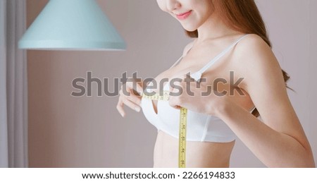 asian happy woman is measuring her body chest and breast size with tape Royalty-Free Stock Photo #2266194833