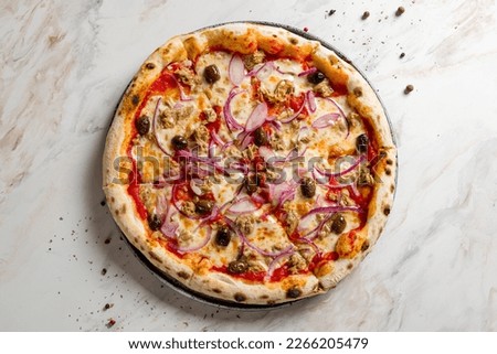 Pizza with tuna and red onion with olives and tomato sauce on marble table top view Royalty-Free Stock Photo #2266205479
