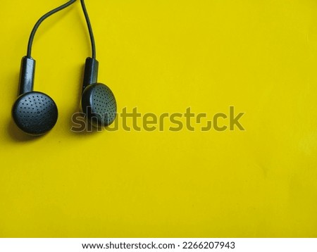 a pair of black headsets on a yellow background