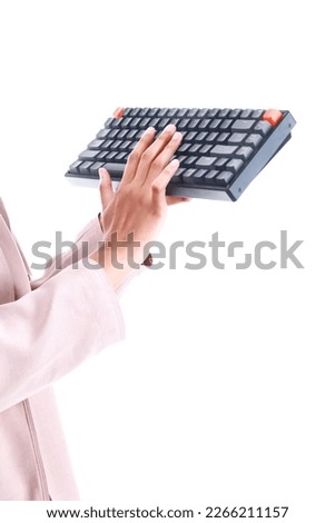 Asian women in corporate outfit holding a wireless keyboard. Office and technology concept.