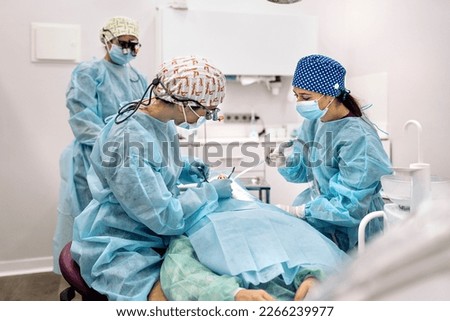 Stock photo of women team wearing face masks and hair nets working in dental clinic.