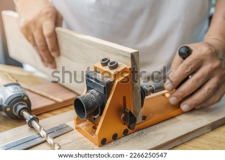 Carpenter use drill bit Pocket hole joinery, or pocket screw joinery, involves drilling a hole at an angle ,make strong joints on wooden plate. D.I.Y and woodworking concept.selective focus. Royalty-Free Stock Photo #2266250547
