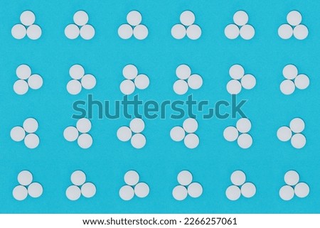 Dose of three white pills, seamless background, on blue.