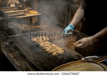Skilled Chef Grilling Authentic Uyghur Lamb Skewers with Fresh Ingredients in the Kitchen