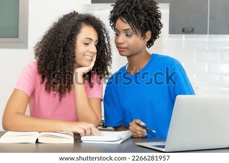 Pretty hispanic and african american female student need private lessons for exam indoors at desk at home